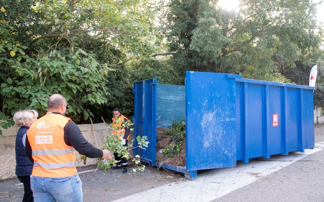 Photo d'une benne pour les déchets avec les agents de Nîmes Métropole