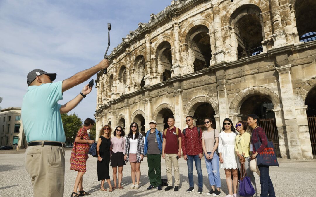 Touristes qui se prennent en photo devant les arènes de Nîmes