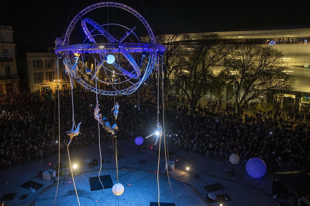 photo du spectacle Galiléo Globe qui flotte dans les airs avec des acrobates Arènes de Nîmes