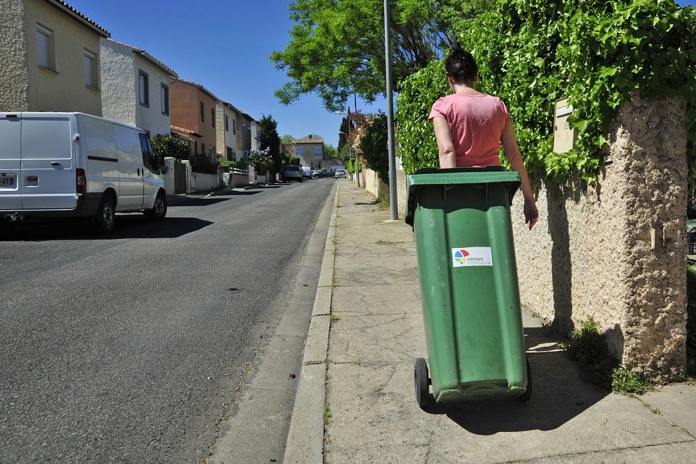 Photo d'un usager Nîmois qui sort sa poubelle